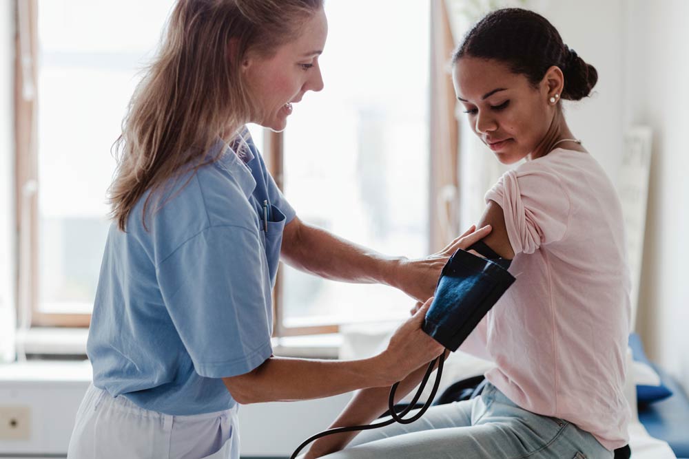Sjuksköterska som mäter blodtryck på patient
