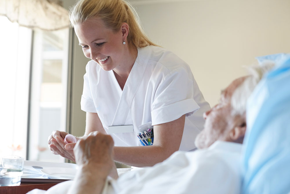 Glad sjuksköterska som hjälper patient