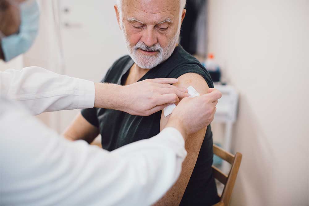 Man som får vaccin i armen